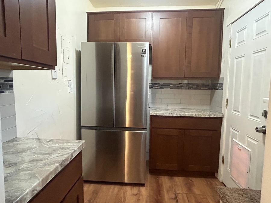 Butler pantry with extra cabinets and counter space and French door style refrigerator