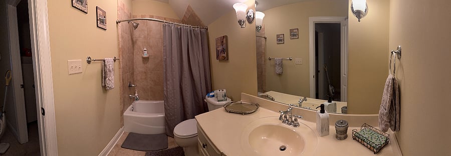 Clean private bathroom with full vanity, mirror, and tub/shower combination