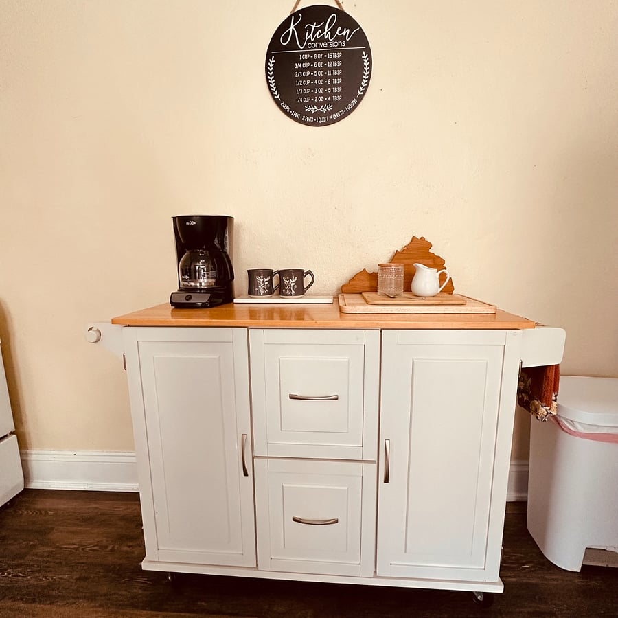 Island with several cutting boards and coffee service.