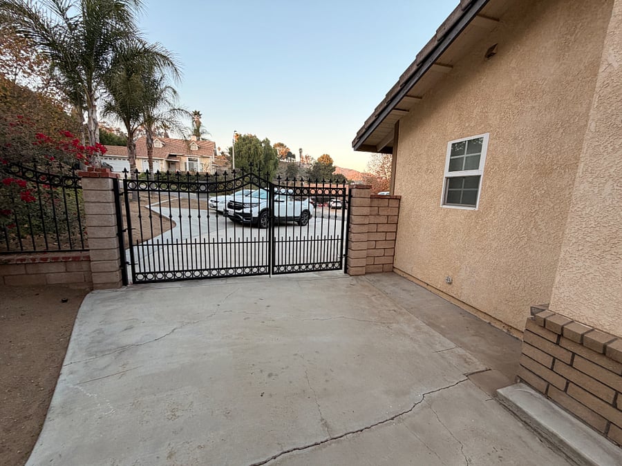 gated front entrance with driveway parking area in foreground