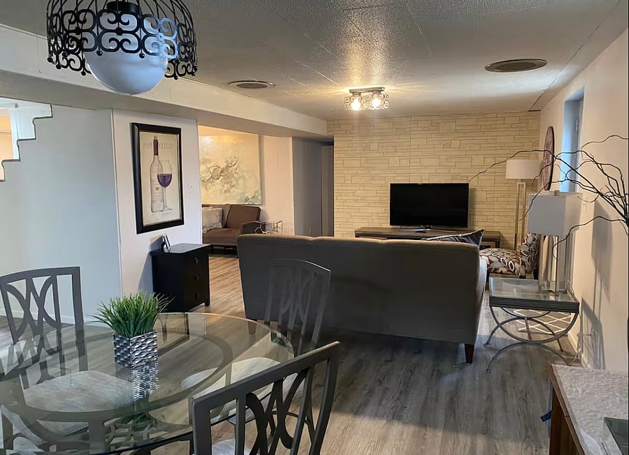 Large Family Room in basement, perfect for family gathering, game room, or movie night on large 65-inch smart TV.
