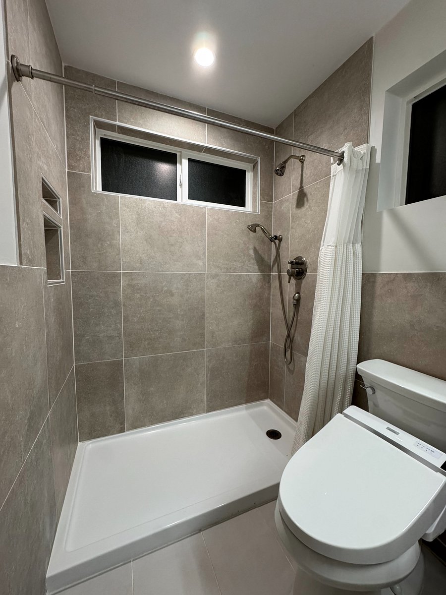 Clean shower, toilet with TOTO bidet, and vanity.