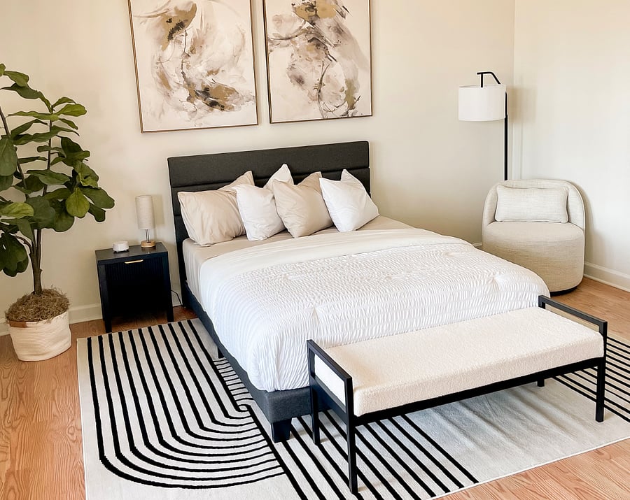 Bright bedroom with queen bed, large windows, and plenty of natural light. Includes sitting nook for reading and relaxation.