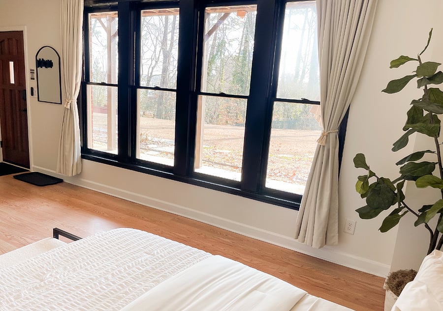 Large windows provide abundant natural light, with blackout curtains for privacy and restful sleep.