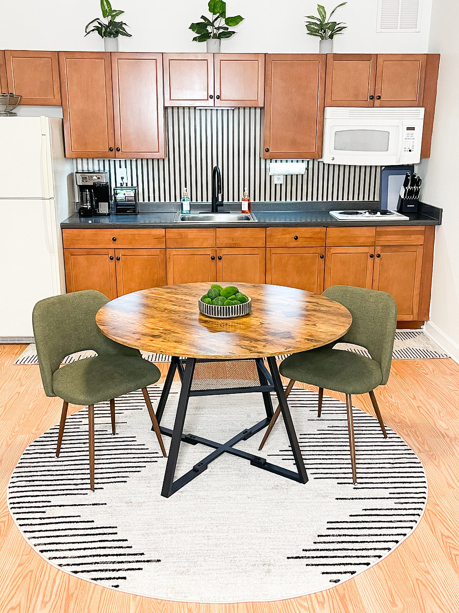 Full kitchen with electric cooktop, refrigerator, microwave, sink, and dedicated dining space.