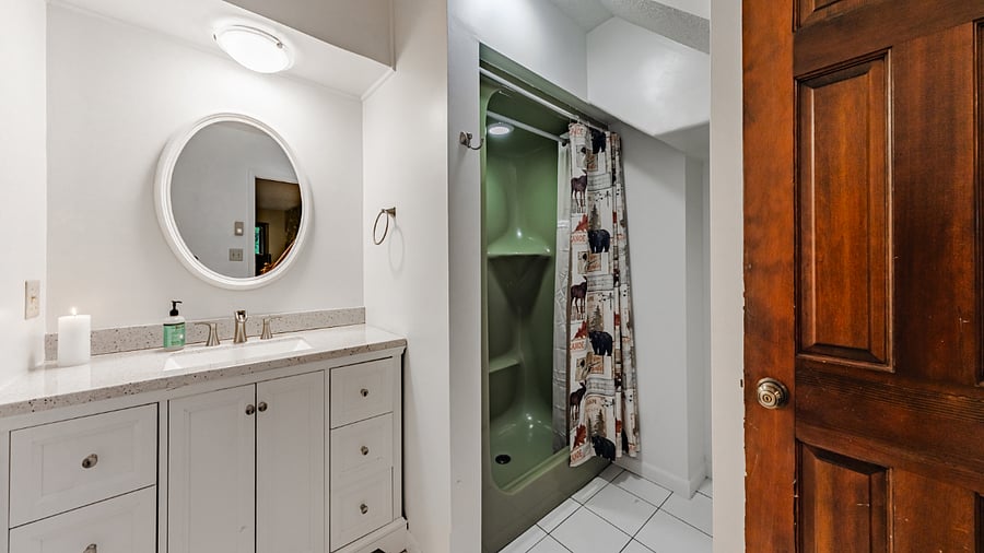 Bathroom under stairs serving lower-level living area and bedrooms