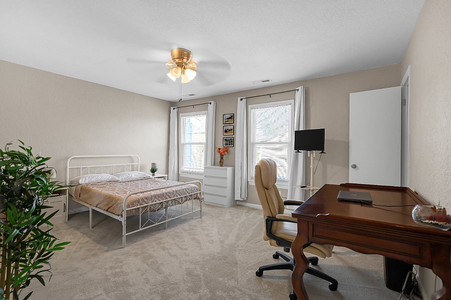 Rest comfortably in a full-size bed or stay productive at the dedicated workspace. Natural sunlight pours through two large windows, filling the space with a calm, airy brightness. Bedroom #2