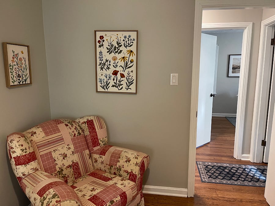 small bedroom reading chair and view back into hallway