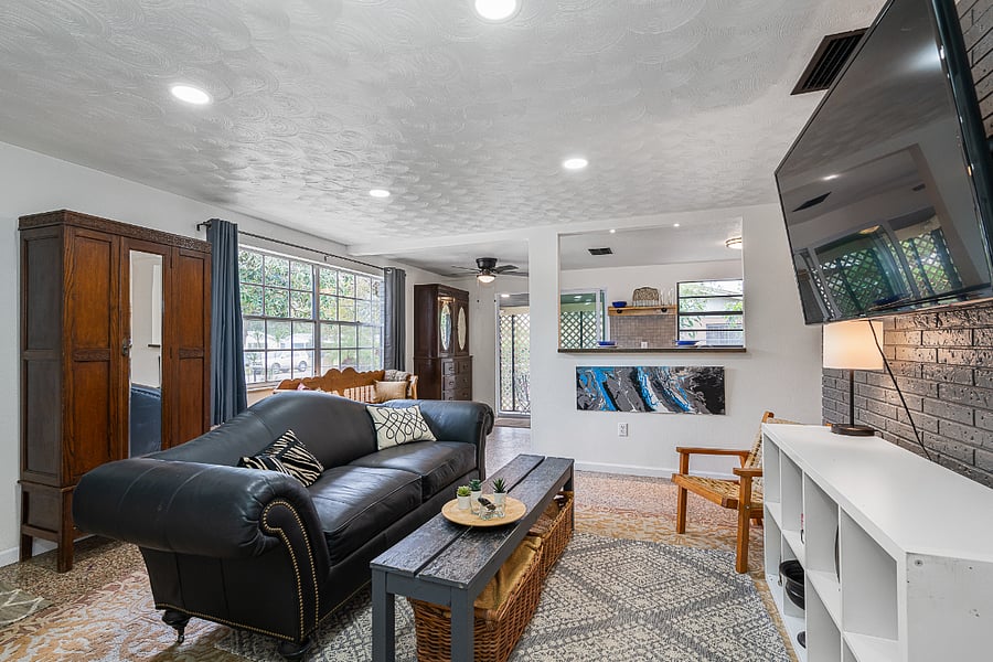 Living room with couch and large windows.