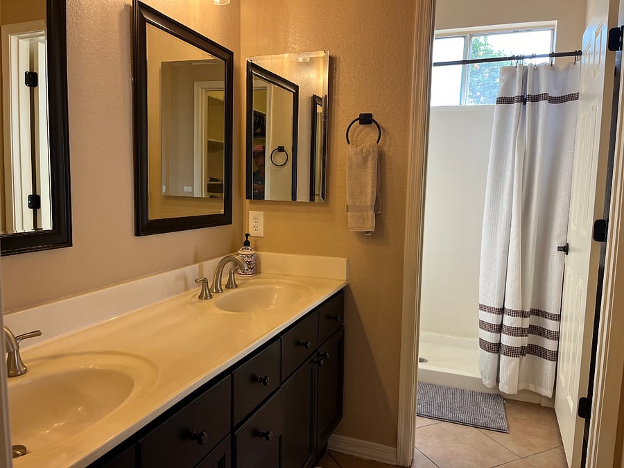 Master bathroom with walk-in closet, walk-in shower with bench and his and her sinks.