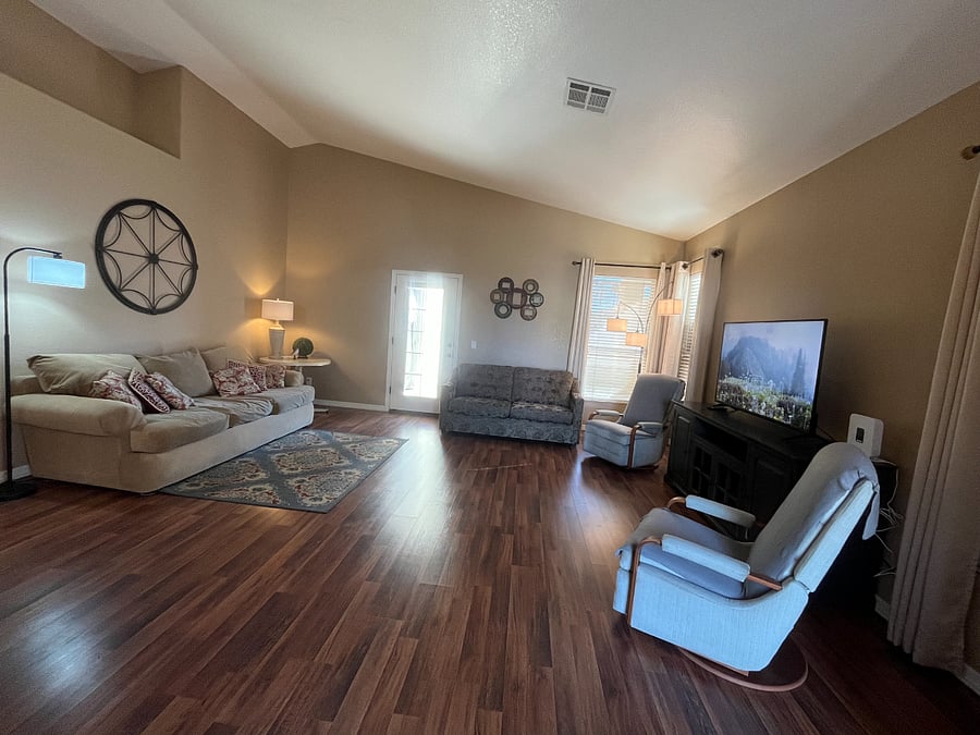 Spacious Living Room with couch, love seat and 2 reclining rockers. Door that leads to back patio