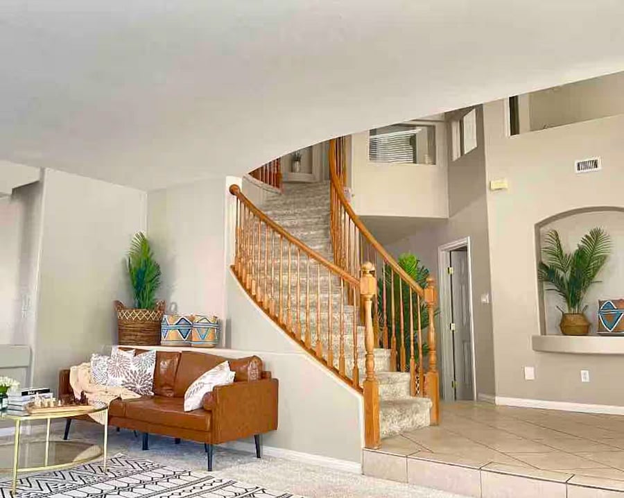 Welcoming entryway with staircase leading to upper-level bedrooms.