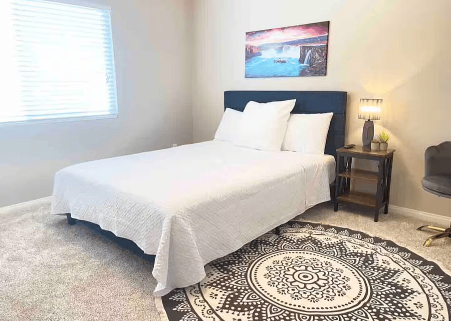 Comfortable queen bedroom with a clean, peaceful layout designed for rest.