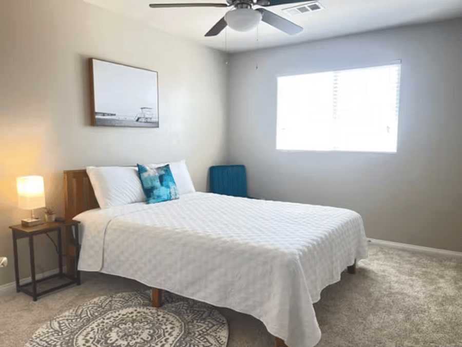 Fourth bedroom featuring a queen-size bed, ceiling fan, and natural light comfortable and well-suited for extended stays.