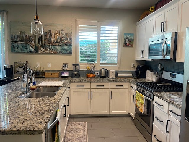 Stainless steel appliances, granite countertops, gas range, microwave, dishwasher, pantry, small appliances, plantation shutters