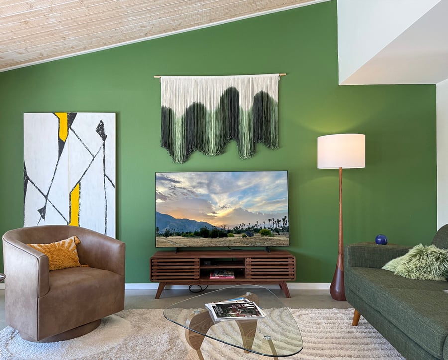 Spacious living room with large smart TV and high ceilings.