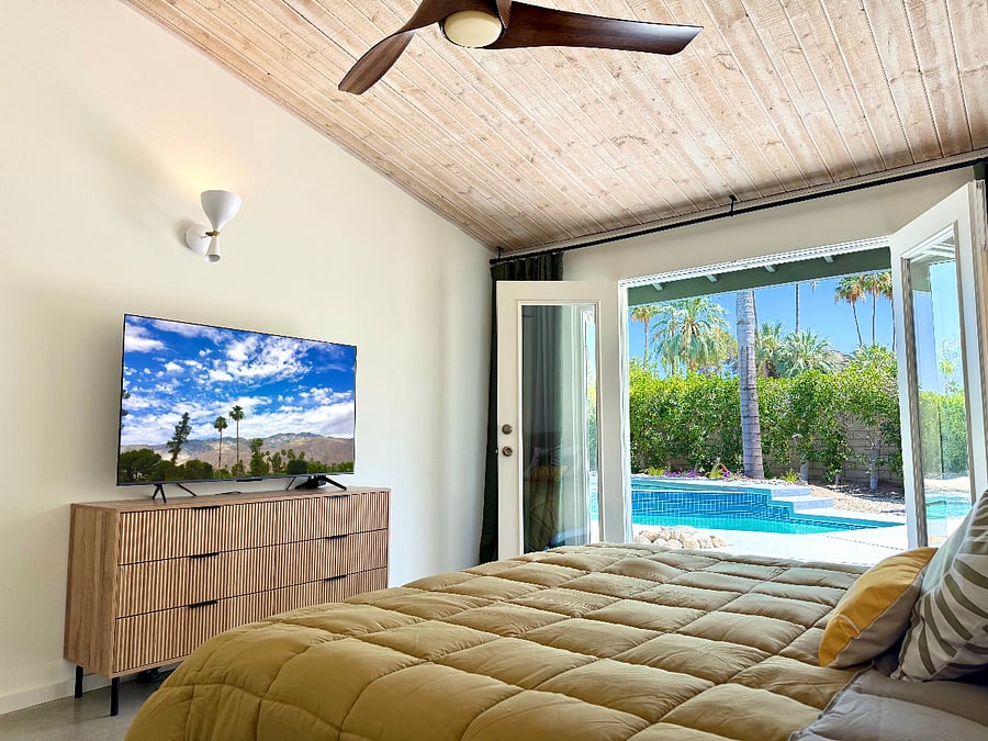 Primary bedroom with large smart TV opens to pool and spa.