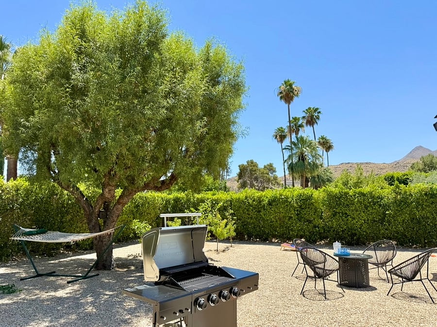 Large backyard with BBQ grill, fire table and hammock for napping.