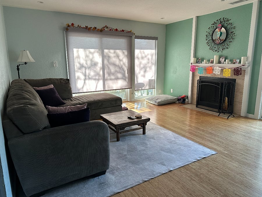 View from entryway of living room, fireplace, and wraparound balcony