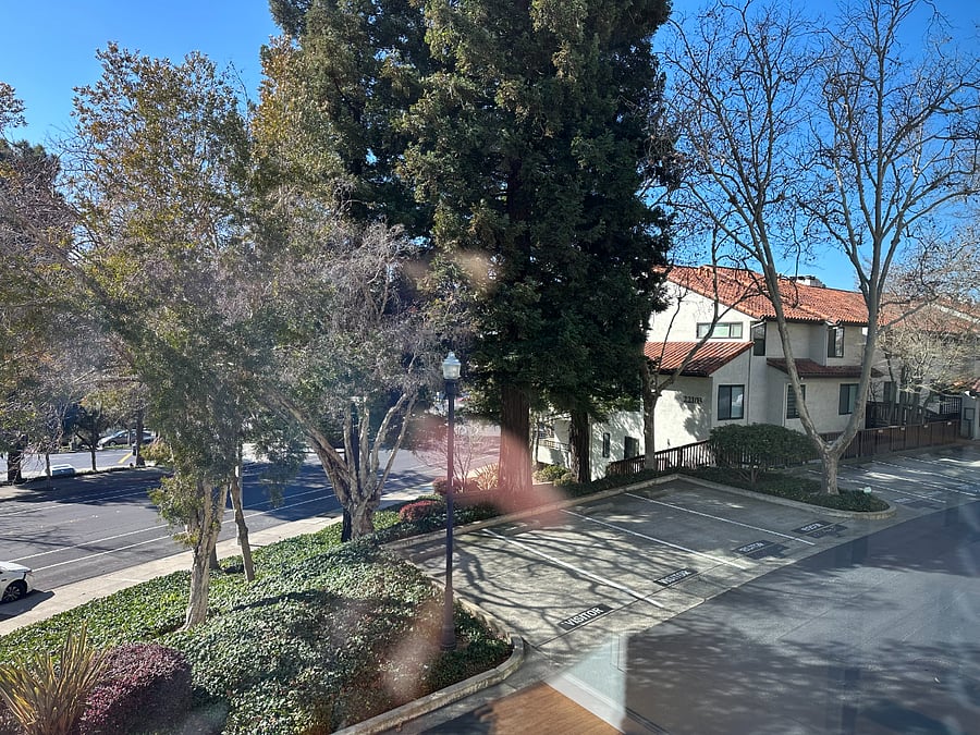 View out the dining room windows of street parking and visitor parking spaces 
