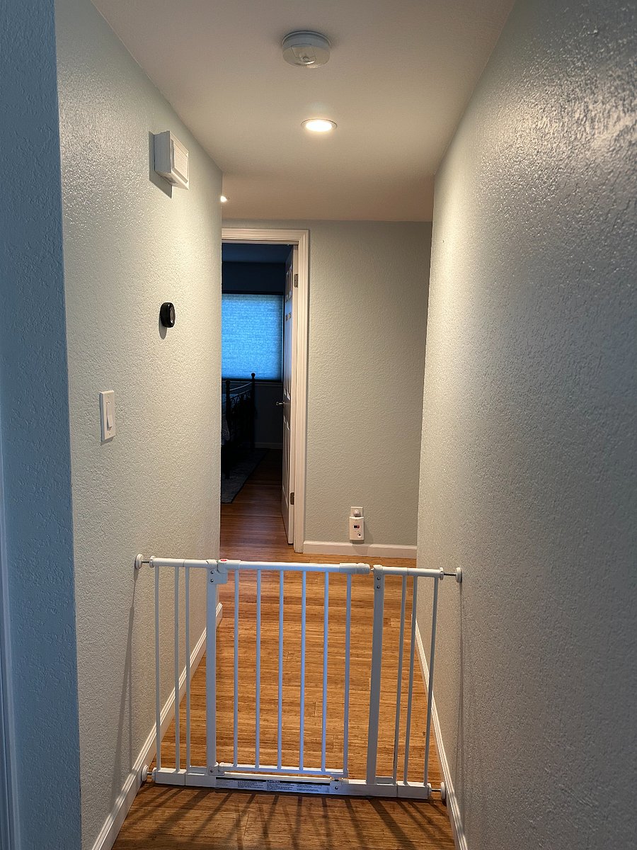 View from entry bench of hallway to bedroom entrance, with shared bathroom to the left