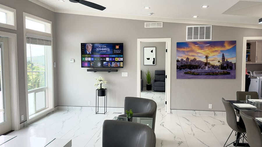 The living area features an electronic leather reclining sofa, complemented by two individual rotating leather chairs and a stylish coffee table. Large windows provide panoramic mountain views, creating a refined and relaxing atmosphere throughout the space.