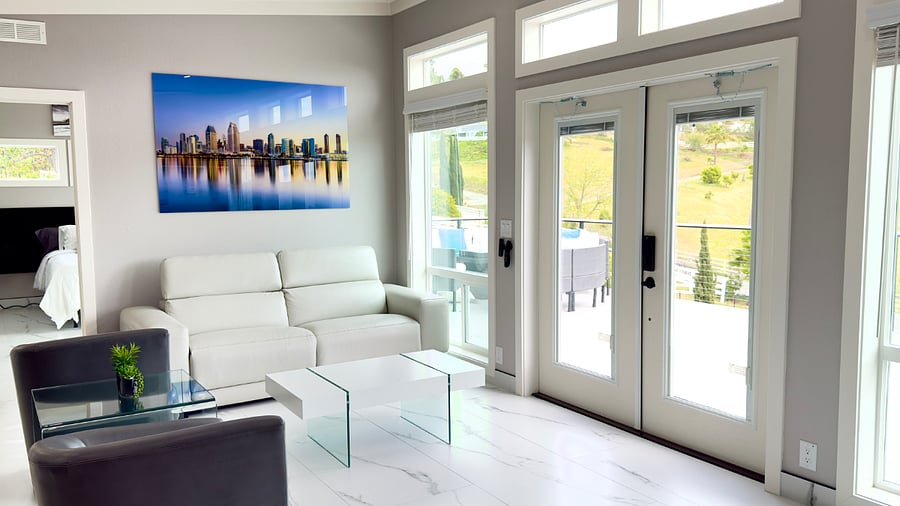 The living area features an electronic leather reclining sofa, complemented by two individual rotating leather chairs and a stylish coffee table. Large windows provide panoramic mountain views, creating a refined and relaxing atmosphere throughout the space.