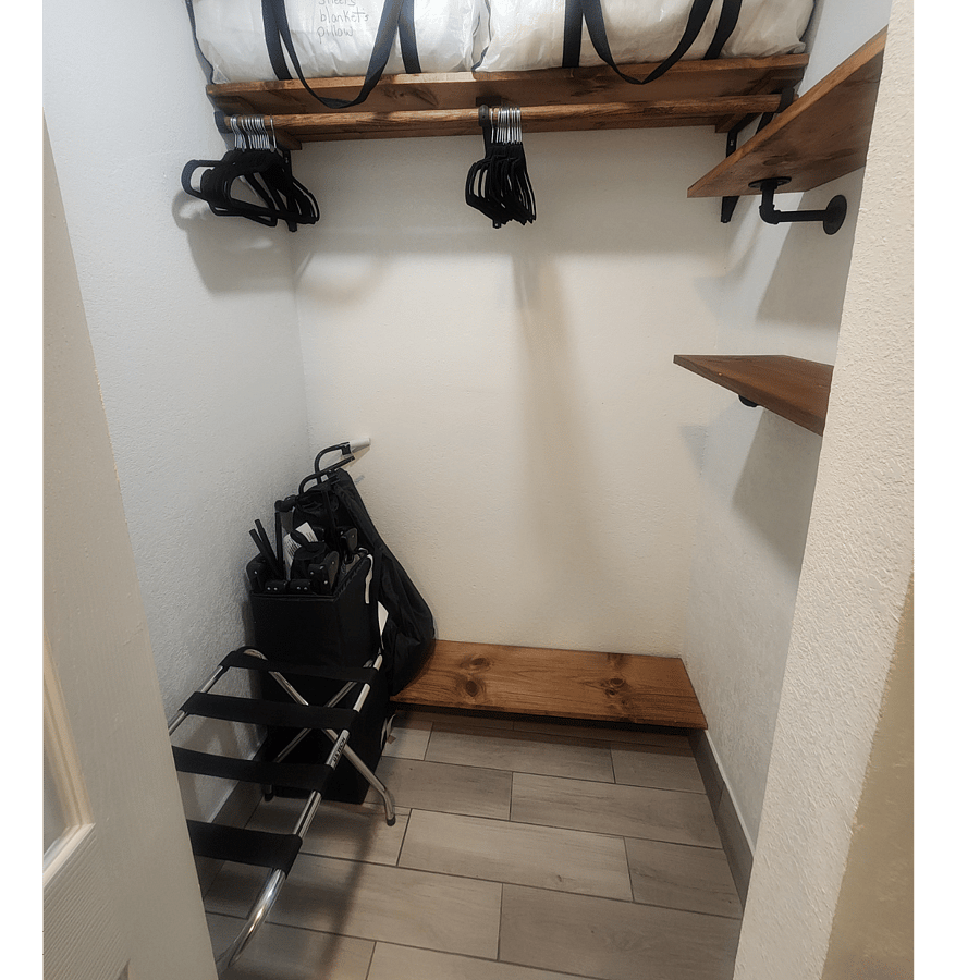 closet with hangers, luggage rack and a baby toddler playpen if need. extra pillows and blankets. foot board for shoes and shelving for extras.