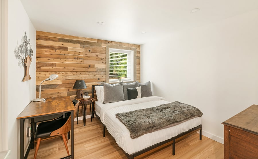 The Wood Room:
- Back bedroom with rustic wood accent wall and soft memory foam bedding  
- Work desk and chair for remote working or writing space  
- Cozy retreat with natural light and warm inviting decor  
- Cowhide dresser, additional storage
- Smart TV with streaming channels, phone charger, sound machine, blackout curtains