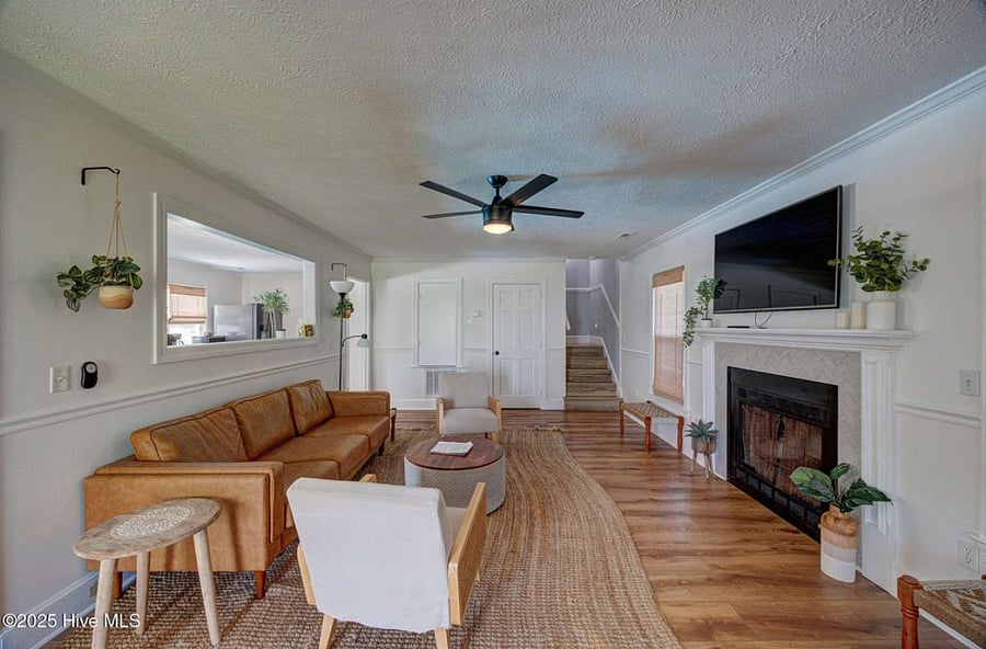Open-concept living area with cozy seating and a fireplace, flowing seamlessly into the fully equipped kitchen perfect for relaxing or entertaining