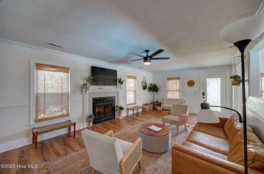 Open-concept living area with cozy seating and a fireplace, flowing seamlessly into the fully equipped kitchen perfect for relaxing or entertaining