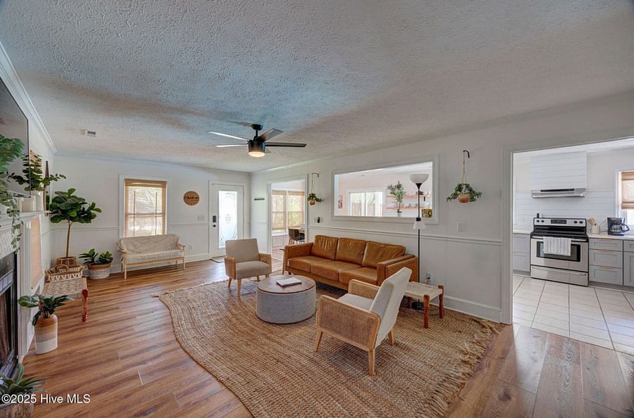Open-concept living area with cozy seating and a fireplace, flowing seamlessly into the fully equipped kitchen perfect for relaxing or entertaining