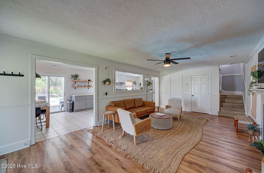 Open-concept living area with cozy seating and a fireplace, flowing seamlessly into the fully equipped kitchen perfect for relaxing or entertaining