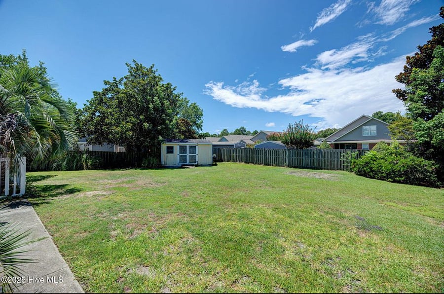 Large backyard with plenty of open space and a shed for storage a flexible area for outdoor activities, pets, or additional gatherings.