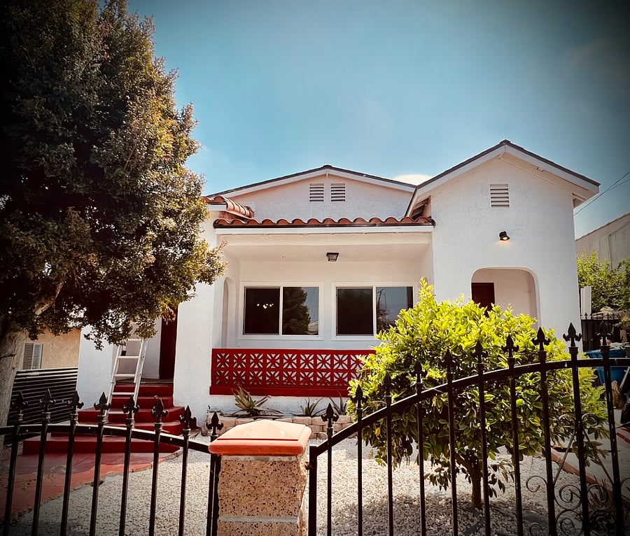 Spanish style exterior with fruit trees and front yard.
