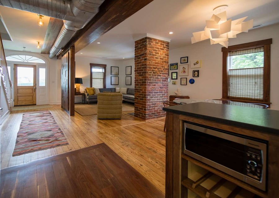 Living and Dining areas from the kitchen showing the microwave, bar sink, and wine shelving.