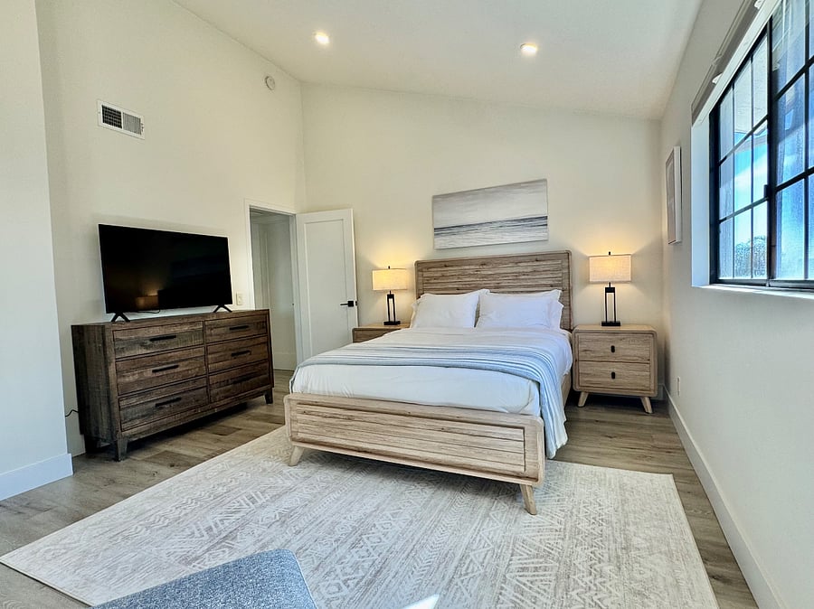 Spacious main bedroom with ensuite private bathroom, 55" LG smart tv, and sitting area