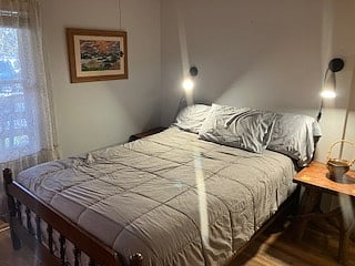 Another view if the master bedroom with reading lights, side tables, fill closet and dresser