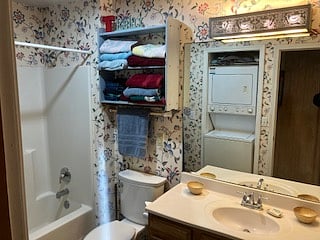 View of towels shelves, vanity with large mirror, plenty of lighting, and other amenities