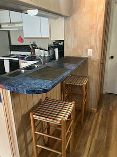 The breakfast bar with seating for two is located between the kitchen and dining room area.