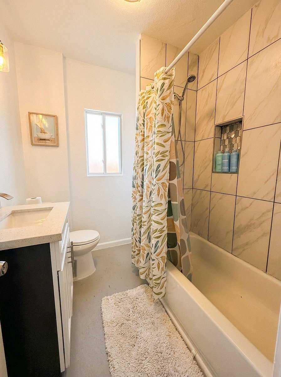 Clean full bathroom with tub shower and fresh towels