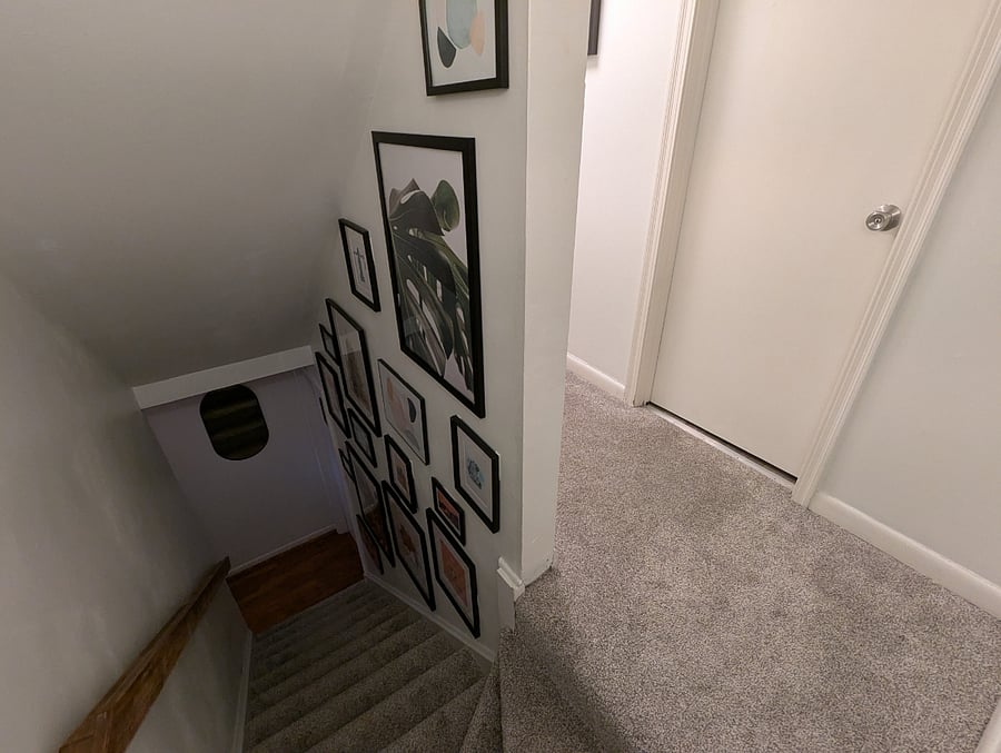 View of 1st floor ascending staircase, from outside bathroom on 2nd floor