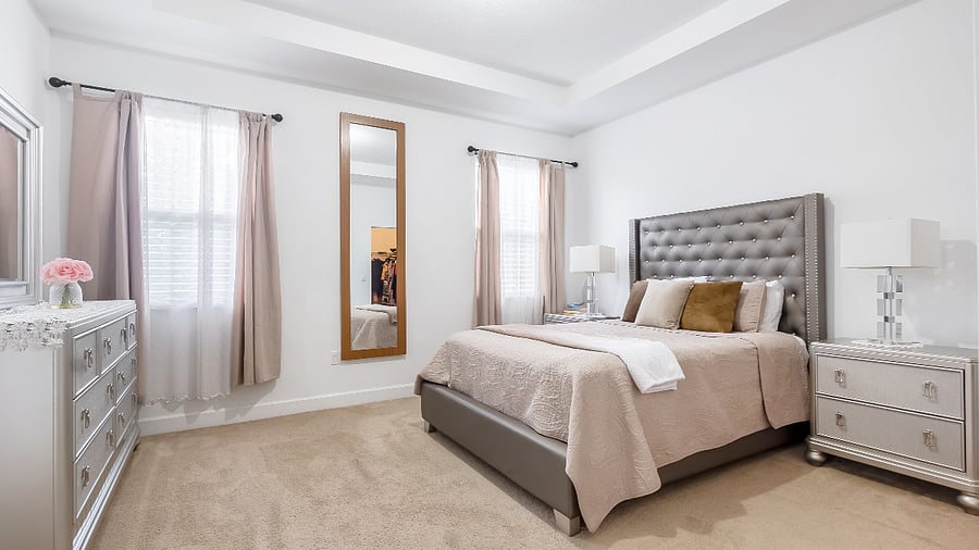 Large master bedroom with ample lighting, high ceilings, walk in closet, and en-suite batheroom.