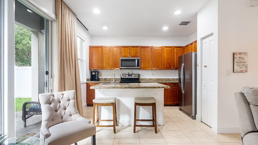 Modern kitchen with stianless steel appliances. Refrigerator with ice maker and water dispenser, microwave, electric glass top stove, full-size oven, and dish washer.