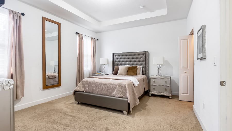Large master bedroom with ample lighting, high ceilings, walk in closet, and en-suite batheroom.