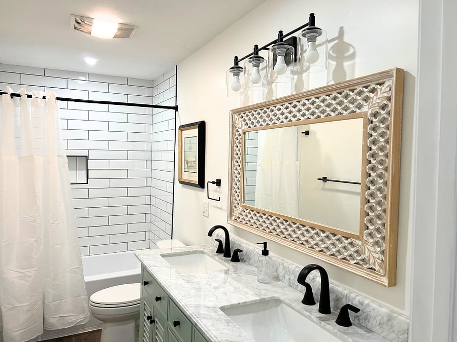 Bright modern bathroom with double vanity, subway tile shower, and bathtub.