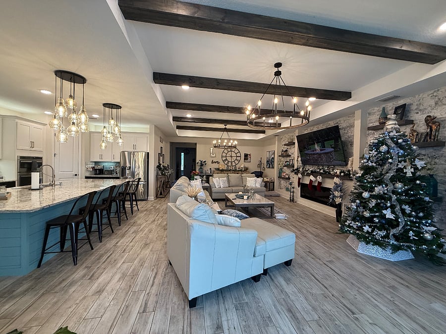 Shared open living space with kitchen, dining. Space features a massage chair and big screen smart TV.