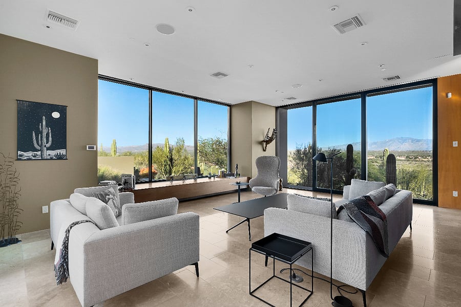 Light-filled living room with floor-to-ceiling glass framing uninterrupted views of the Sonoran landscape.
