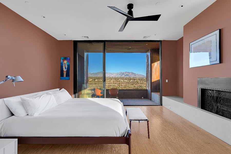 Primary suite with panoramic mountain views, featuring a private terrace, fireplace, and serene minimalist design.