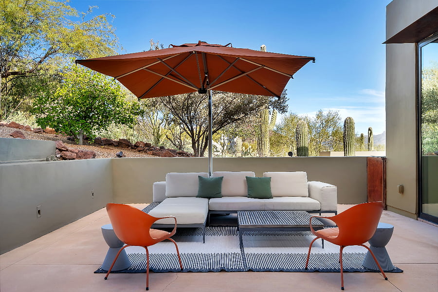 Private outdoor lounge with oversized umbrella, a quiet retreat for morning coffee or shaded afternoon relaxation.